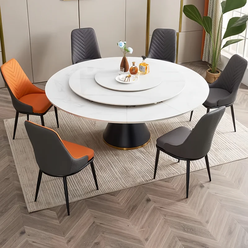 Table de salle à manger ronde avec plateau en pierre frittée et rallonge escamotable pivotante.