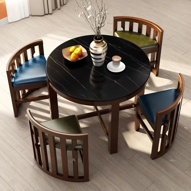 Ensemble table et chaises rondes en bois massif, peu encombrantes, avec chaises intégrées.